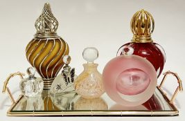 A group of coloured glass perfume bottles (largest h- 20cm), together with a rose gold plated mirror