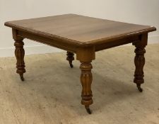 A Victorian walnut dining table, the top with moulded edge raised on turned and carved supports