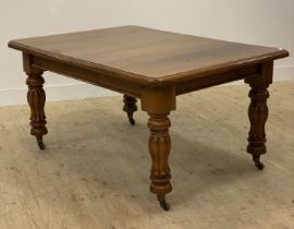 A Victorian walnut dining table, the top with moulded edge raised on turned and carved supports