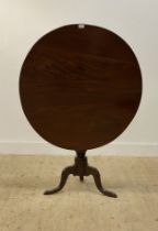 A 19th century mahogany tilt top table, the circular top raised on a turned column and three