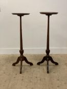 A pair of Georgian style mahogany plant stands, the circular dished tops raised on turned supports