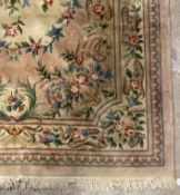 A Chinese super washed wool carpet, the pink ground with floral motifs 395cm x 274cm.