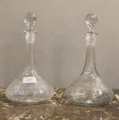 A pair of etched cut glass ships style decanters, each with faceted stopper and trailing foliate