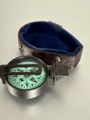 A brass cased pocket compass with green dial with lower section of original case, ( D  x 4 cm)