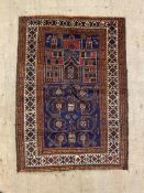 A hand knotted baluchi rug, the blue ground of floral and architectural design within a guarded