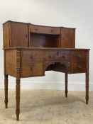A mid 19th century mahogany writing desk, the superstructure with a concave centre drawer flanked by