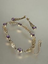 A 9ct gold Celtic knot line style bracelet set five oval amethysts in rub over setting with safety