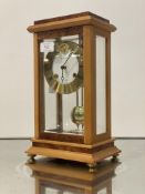 A Franze Hermle & John four glass clock, the case with burr elm veneers, bevelled glass panels,