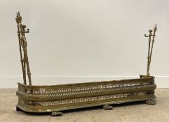 A Regency pierced brass fire fender with rope twist moulding, standing on cast lion paw supports,