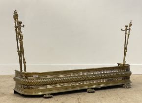 A Regency pierced brass fire fender with rope twist moulding, standing on cast lion paw supports,