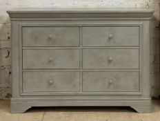 A Traditional hardwood chest of six short drawers, with panelled sides and raised on bracket
