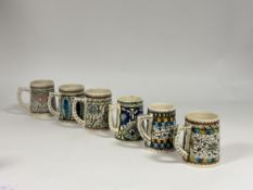 A collection of six Iznik style various pattern hand thrown mugs. (h-13cm) (shows signs of chips and