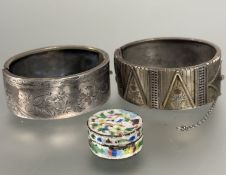 A silver Edwardian stiff hinged bangle with engraved floral panels and safety chain, (H x 2.5 cm x D