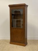 A late 19th / early 20th century stained pine bookcase cabinet, with projecting cornice above glazed