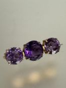 A Edwardian yellow metal amethyst three stone graduated brooch in four claw setting, the center