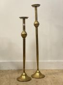 A graduated pair of gilt metal floor standing candle sticks H101cm.