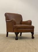 A quality club armchair, upholstered in tan leather and raised on ball and claw carved cabriole