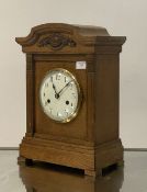 An early 20th century bracket clock, the moulded oak case enclosing a white enamel dial with Roman