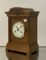 An early 20th century bracket clock, the moulded oak case enclosing a white enamel dial with Roman