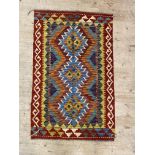 A hand knotted  chobi kilim rug with pole medallion within a running dog border 121cm x 76cm