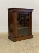 A 19th century mahogany pier cabinet of small proportions, the glazed door opening to shelves to