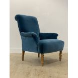 A quality contemporary easy chair, well upholstered in deep blue velvet, raised on turned
