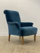A quality contemporary easy chair, well upholstered in deep blue velvet, raised on turned
