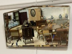 A 1930's frameless bevel edged wall hanging mirror 55cm x 32cm