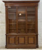 A 19th century well figured mahogany library bookcase, the projecting cornice over a cushioned