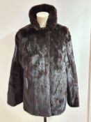 A Lady's dark ranch Mink fur jacket with fold over collar, slash pockets to side and satin lining,