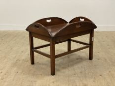 A campaign style mahogany butlers tray on stand coffee table, the lift of top with pierced carry