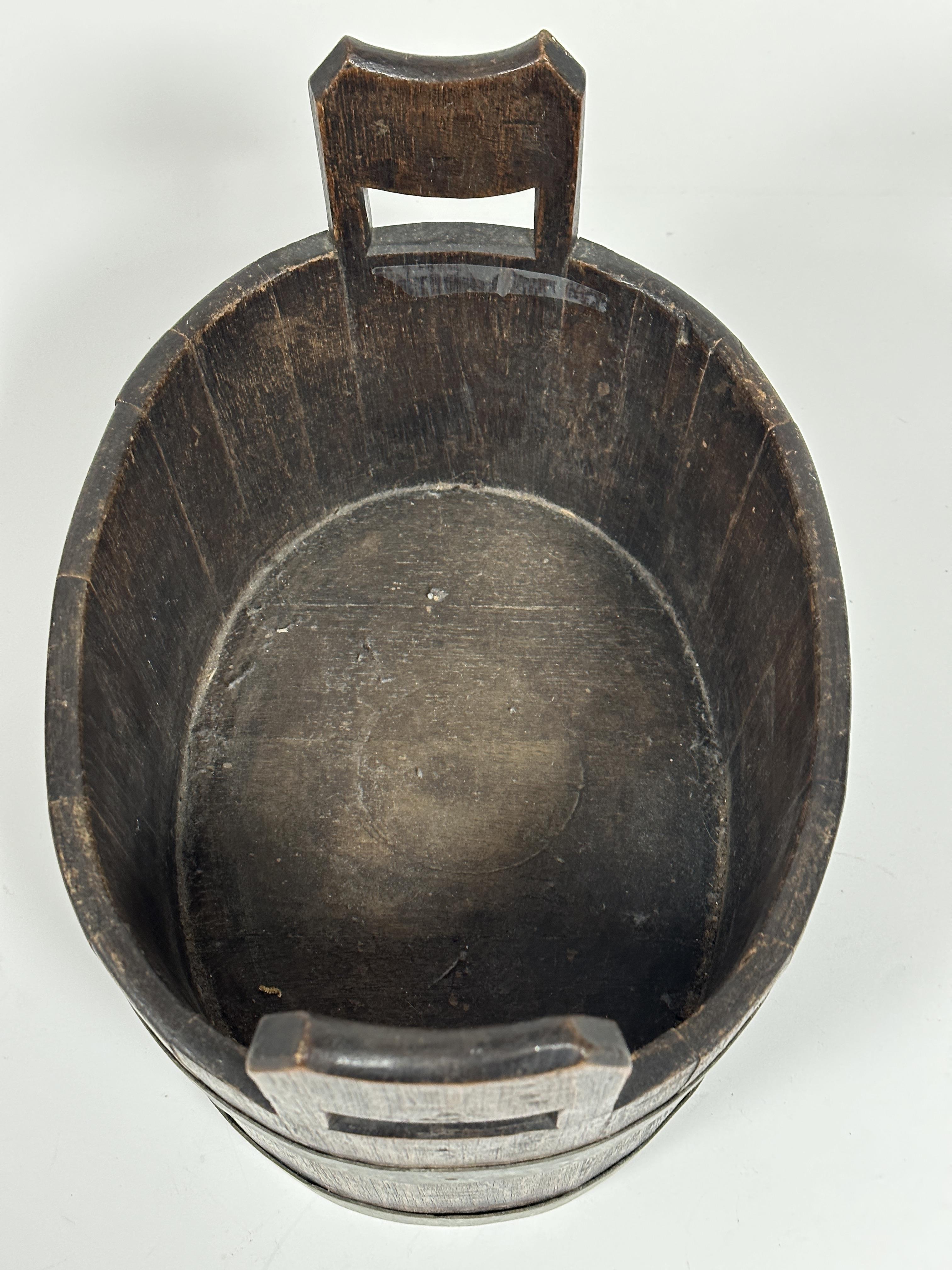 A 1920's oak coopered two handled tub or wine cooler of oval form with twin handles to sides bound - Image 2 of 3
