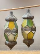 A pair of candle holder lanterns of faceted octagonal form, with openwork decoration and stained and