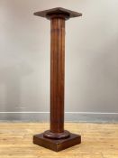 A walnut pedestal of classical design, the square top raised on a gilt metal top fluted column and