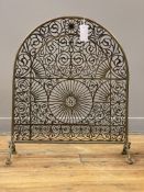 A late Victorian / Edwardian cast brass spark guard of arched form, the open work panel decorated
