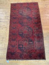 A hand knotted Afghan Bokhara rug of characteristic design 210cm x 117cm.