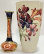 A William Moorcroft conical form vase with tube lined Lilly decoration on a white/cream ground (