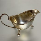 A Sheffield silver sauce boat with scalloped edge and C scroll handle raised on pad feet, (H x 8