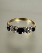 A 9ct gold graduated three stone sapphire ring, the center stone, 025ct flanked by an old mine cut