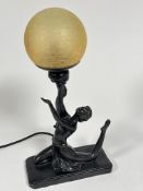A reproduction Art Deco style lamp with seated dancer with arms upraised holding a golden craquelure