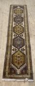 A Persian design runner rug, the dark field with ivory panel having five hexagonal medallions,