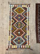 A hand knotted  chobi kilim runner rug of all over geometric design with an ivory border 143cm x