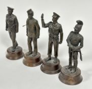 A set of four bronzed finished resin cast military figures raised on circular wood bases, (H x 26