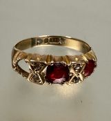 A 9ct gold two stone gem set ring, the centre stone with two rose cut diamonds spacers, one red