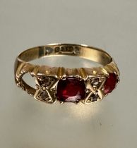 A 9ct gold two stone gem set ring, the centre stone with two rose cut diamonds spacers, one red