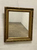 An early 20th century gilt composition and gesso wall mirror, the frame decorated with scrolling
