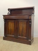 A Victorian mahogany chiffonier, the open shelf on scrolling supports above a frieze drawer and twin