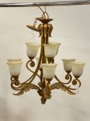 A gilt metal chandelier in the baroque taste, with nine scrolling branches and embellished with