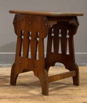 An Arts and Crafts period walnut stool, the top with moulded edge raised on pierced panel end