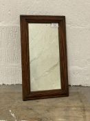 A small 19th century wall hanging mirror in a moulded oak frame 42cm x 24cm.
